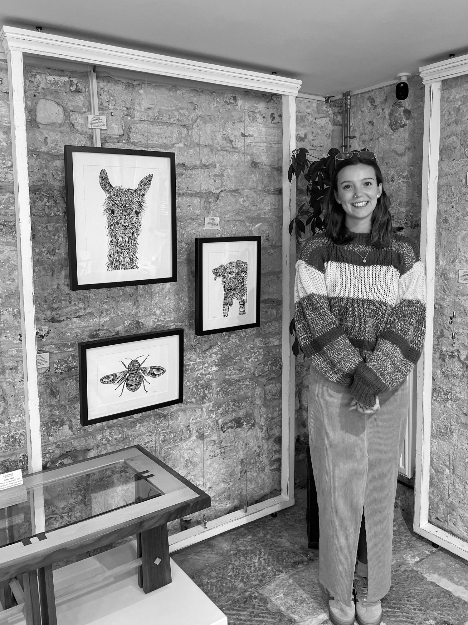 Pia Elliot in front of monochrome, hand drawn, pen and ink artwork of wildlife and animal in Dorset gallery
