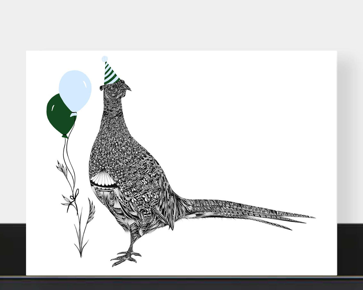 A horizontal greetings card featuring a detailed black-and-white illustration of a pheasant wearing a party hat, with two balloons in dark green and pale blue, shown against a white background.